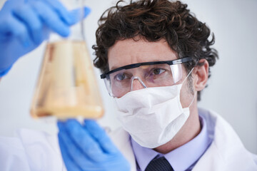 Poster - What could this mean. A cropped shot of a scientist examining a flask filled with liquid.