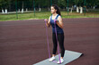 © etonastenka - Young woman shakes muscles in her arms using an expander and fitness elastic bands. beautiful young sportswoman training with stretching band