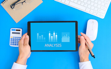 Poster - Businessman examines sales data and an economic growth graph graphic on a tablet and laptop. This is a business strategy. Digital marketing is a term that refers to the use of Technology concept 