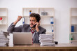 © Elnur - Young male employee unhappy with excessive work in the office