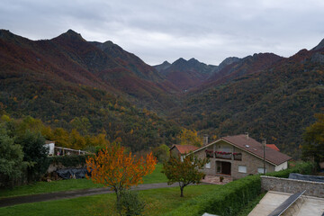 Wall Mural - Houses in Picos de Europa nationalo park with mountains on the background during Autumn fall, in Spain