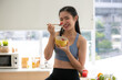 © chokniti - young Asian woman cooking vegetable healthy food and eating or drinking in home kitchen