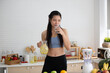 © chokniti - young Asian woman cooking vegetable healthy food and eating or drinking in home kitchen