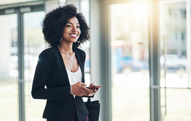 Aufkleber - Im excited for this meeting. Shot of a confident young businesswoman texting on her phone while standing in the office at work.