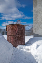 Compost Barrel On A Snow-covered Garden Plot In Early Spring