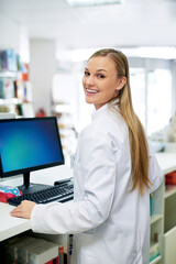 Poster - Keeping track of orders with technology. Shot of a young pharmacist using a computer at the checkout counter.