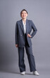 © Timeimage - Young Asian business woman standing on gray background