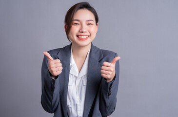 Wall Mural - Portrait of a beautiful Asian businesswoman on a gray background