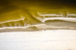 Morze Bałtyckie, widok z lotu ptaka z drona lecącego nad pustą, piękną plażą. Drobne fale rozbijające się o piaszczystą plażę.
