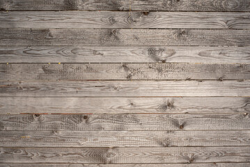 a weathered wall of pine planks in sunlight