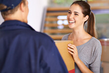 Expressing Delight At Receiving Her Express Delivery. Shot Of A Courier Making A Delivery To A Happy Customer.