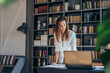 © undrey - Business woman stands at her work table and looks at documents
