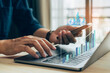 © kelvn - Businessman working stock traders making analysis of digital market and investment, technical chart red and green and laptop screen background for stock trading.
