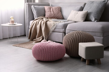 Wall Mural - Stylish poufs and ottoman near sofa in living room. Interior element