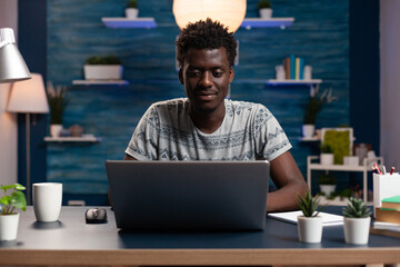 Poster - Careful student man sitting at desk in living room working remote from home at financial project using laptop computer for online webinar. Freelancer having business lesson during distance education