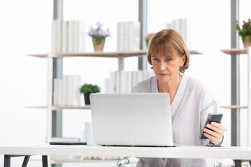 Wall Mural - senior businesswoman or freelancer looking smartphone for checking something for work