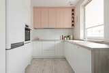 Fototapeta  - Kuchnia w minimalistycznym nowoczesnym stylu. Białe i różowe fronty mebli oraz sprzęt. Biała lodówka