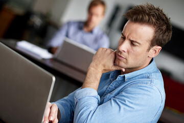 Poster - Focused on the finer details. Shot of a man working on a laptop in an office.