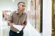 © JackF - Adult man is visiting museum and looking at the exposition with information brochure indoor.
