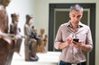 © JackF - Adult male is visiting at the exposition and talking by phone in the museum.