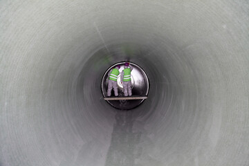 Wall Mural - Man in a big pipe 2. Human inside a large shiny metal pipe