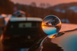 Crystal ball sunset shot with reflections on a car roof at Kostenz, Bavarian forest, Bavaria, Germany