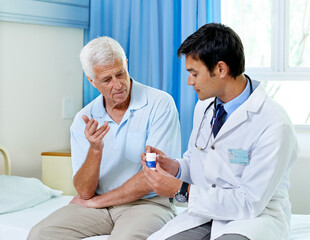 Poster - Just take one a day. Shot of a handsome young doctor explaining medication to a senior patient.