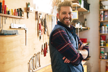 Poster - Hes a confident craftsman. Portrait of a handsome young handyman standing with his arms folded in a workshop.