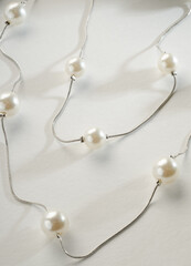 Wall Mural - Fashion jewelry - double silver chain with white beads on a white background.