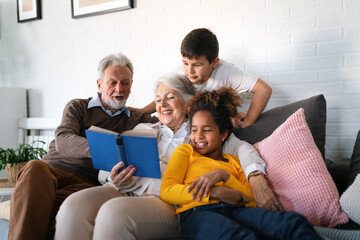 Wall Mural - Multiethnic mixed race family education at home. Grandparents with children