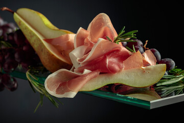 Wall Mural - Prosciutto with rosemary, pear, and grapes.