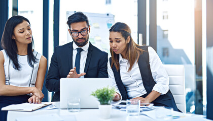 Poster - We need to figure this out first. Cropped shot of a group of young businesspeople having a discussion while using a laptop in a modern office.