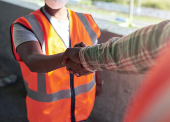 Poster - Lets work together to build even better. Shot of two builders shaking hands at a construction site.
