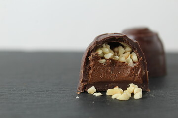 Canvas Print - CHOCOLATE CASE CANDY WITH CHOCOLATE FILLING PRALINE GANACHE AND CRUSHED PEANUTS ON A GRAY BLACK BACKGROUND. Day of chocolate sweets without diet