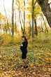 © Anhelina  - Beautiful pregnant woman in a black dress in the autumn park. Golden autumn. Fallen leaves. Awaiting the birth of a child.