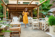 © phpetrunina14 - Woman in yellow dress walking by cafe terrace