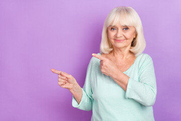 Wall Mural - Photo of confident old grandma indicate finger empty space tips concept wear blue shirt isolated violet color background