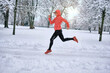 © Andrii IURLOV - Running woman, girl runner on snow in park in winter sunny day.