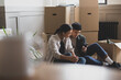 © ReeldealHD images - Mid adult couple sitting on the floor of their new home surrounded by boxes