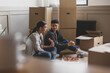 © ReeldealHD images - Mid adult couple sitting on the floor in new home eating pizza