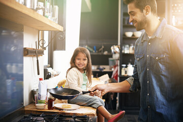 Wall Mural - Dad makes the best pancakes ever. Shot of a father and daughter making pancakes together.