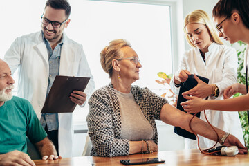 Wall Mural - Group of young doctor during home visit senior people, control blood pressure.