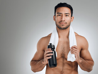 Poster - If you want it bad enough, youll sweat for it. Shot of an athletic man holding a bottle of water while standing against a grey background.