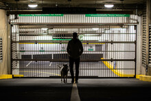 View Of A Person Male With His Dog In Front Of Car Park In Downtown Vancouver, Canada