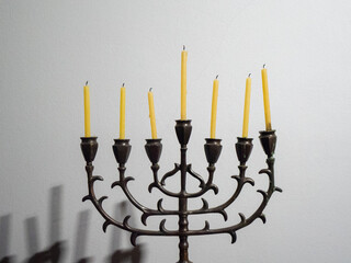 Wall Mural - Closeup shot of a seven-branched candelabra with candles on a white background for Hanukkah