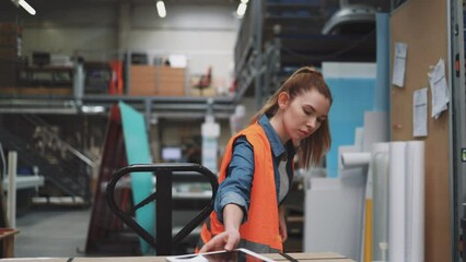 Wall Mural - Young worker moving goods on pallet jack at warehouse
