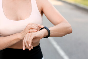 Sticker - Female runner checking pulse outdoors, closeup