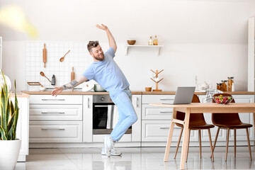 Sticker - Cool young man with laptop learning to dance at home