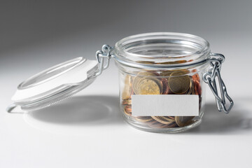 Wall Mural - charity, donation and saving concept - close up of coins in glass jar