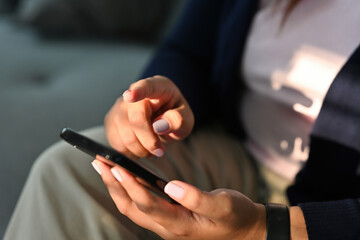 Poster - Cropped view hand holding a smartphone and pointing to the screen, for business and technology concept.